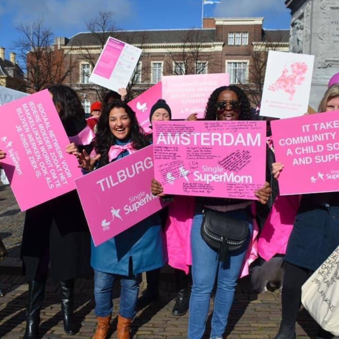 A group of women holding pink posters for Single SuperMom