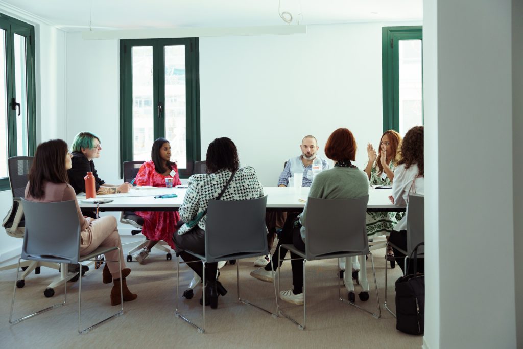 People talking at the AGE event in a boardroom