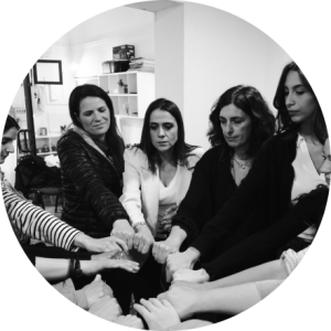 Group of women joining hands to form a circle. Photo in black and white.