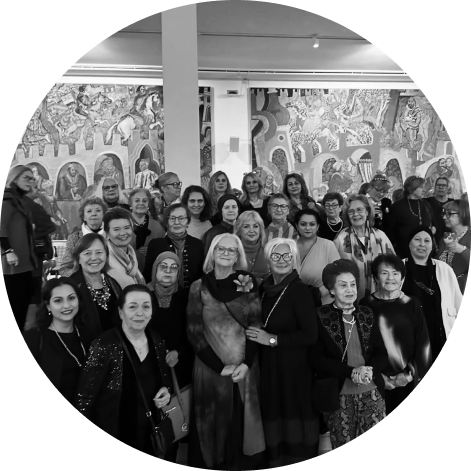 Large group of women smiling at the camera. Photo in black and white.