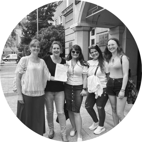 Group of women smiling at the camera. Photo in black and white.