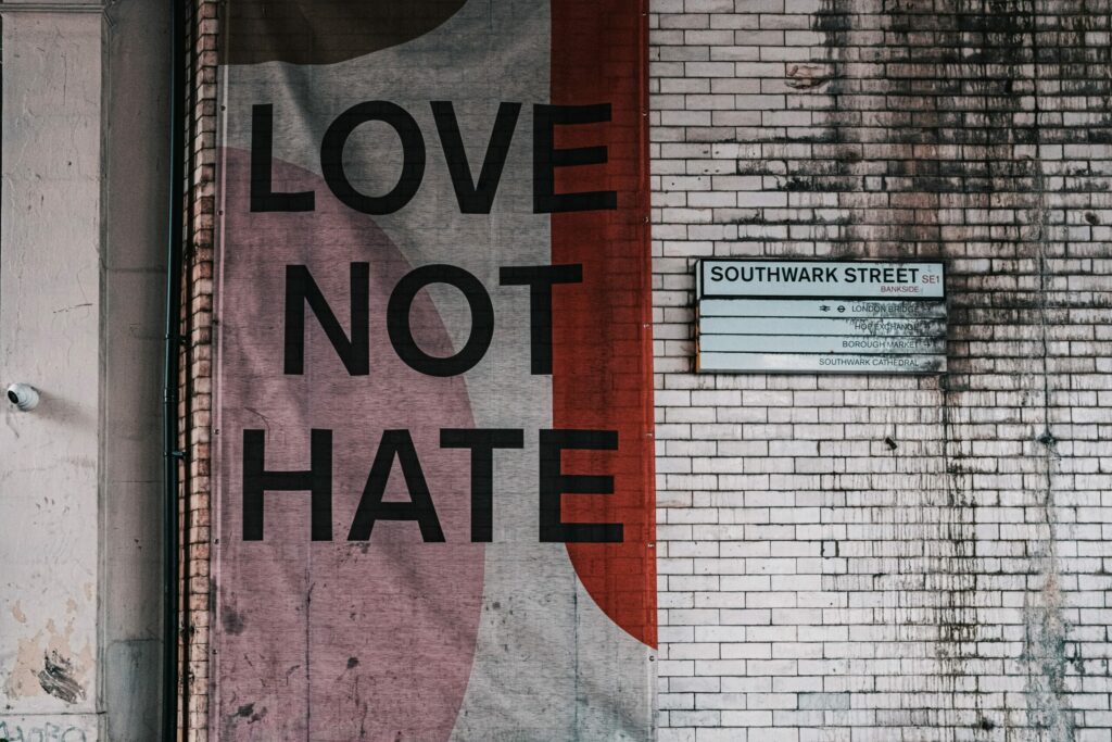 Print on a white brick wall with the words "Love not hate".