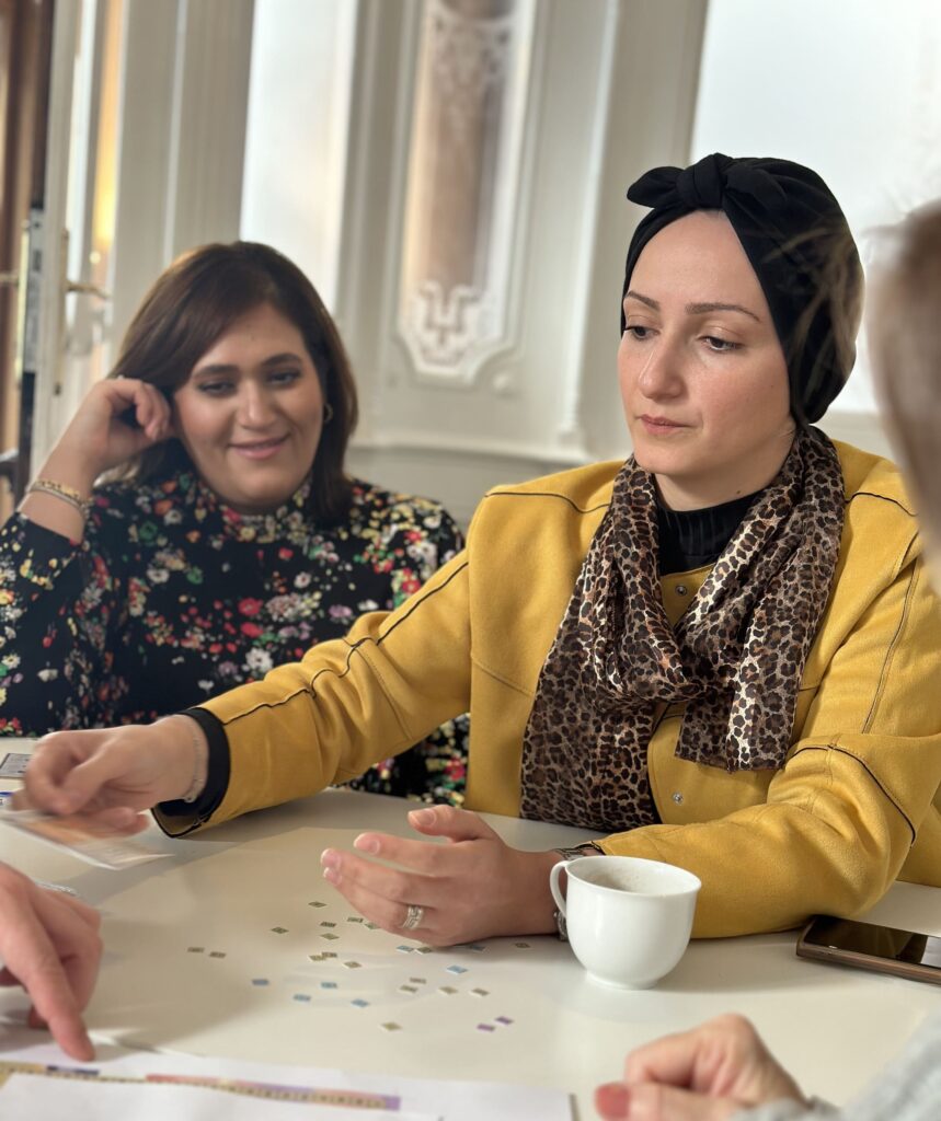 Two women sitting beside a table smiling